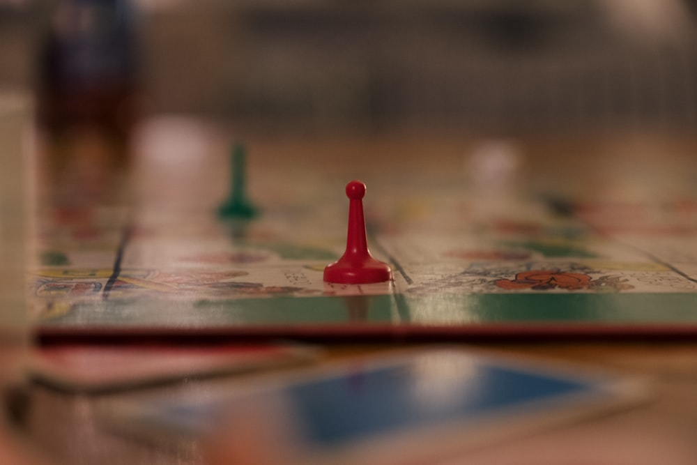 red and green chess piece on brown wooden table