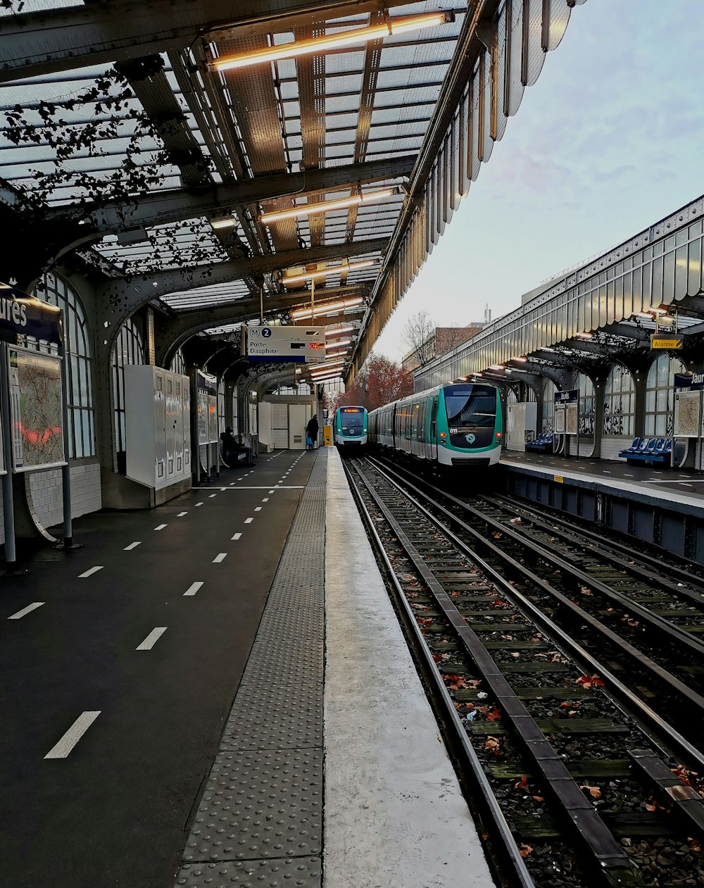 blau-weißer Zug tagsüber am Bahnhof