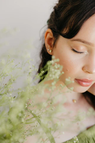 A serene woman with radiant skin surrounded by natural herbs and subtle digital elements symbolizing the fusion of Ayurveda and AI.