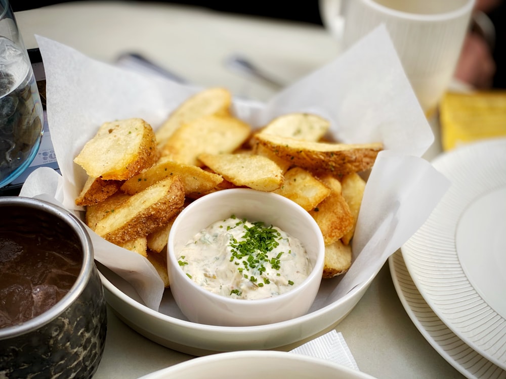 potato fries and green vegetable salad on white ceramic bowl