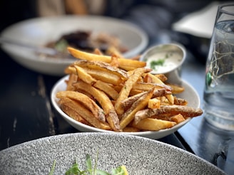 A plate of crispy golden fries served with dipping sauces.