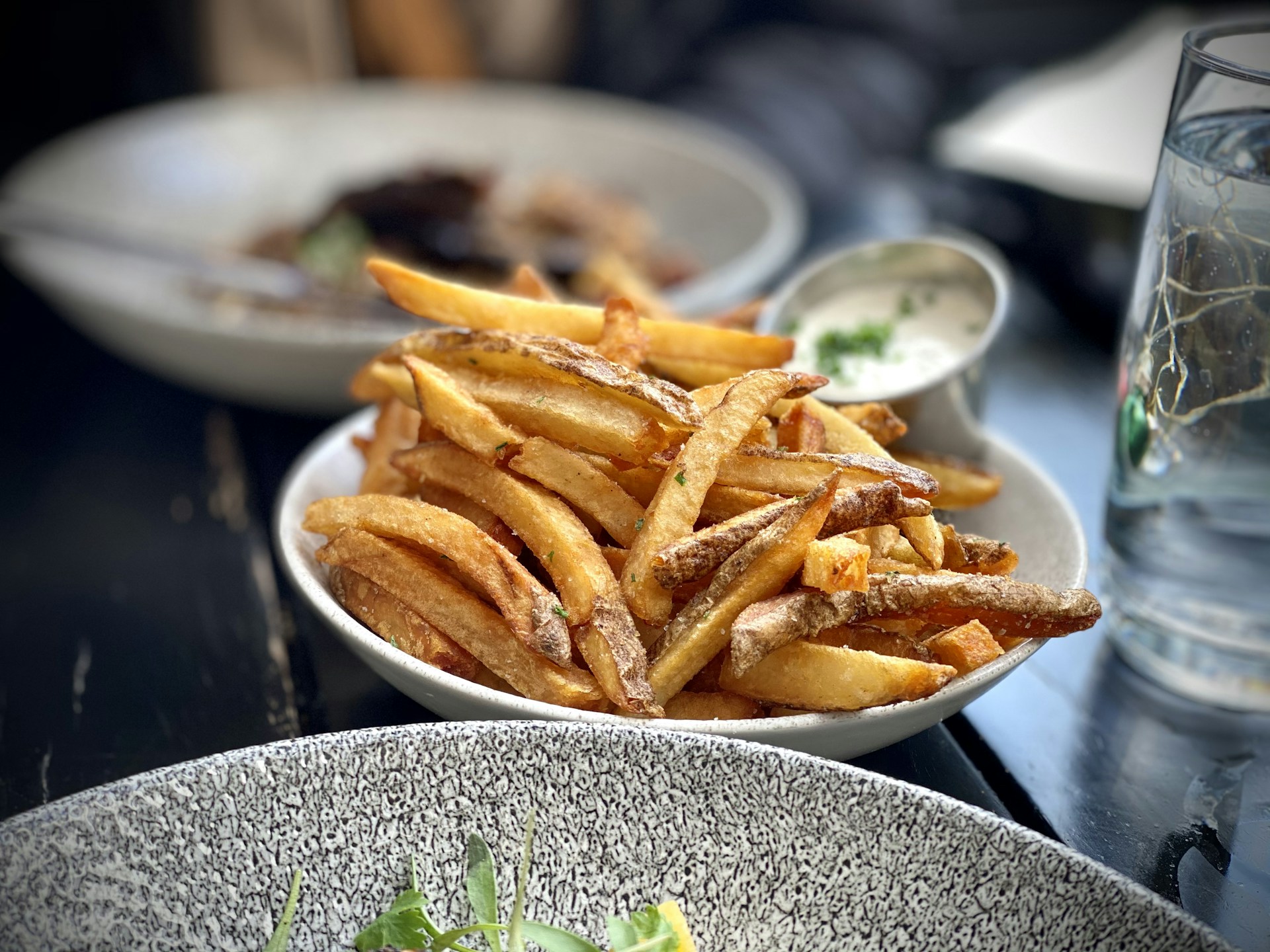 A vibrant plate of golden, crispy fries alongside a colorful dipping sauce, captured in the warm, cozy ambiance of bite n chill.