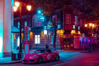 A vibrant night shot of a neon-lit car show with synth pop inspired lighting and dark cityscape.