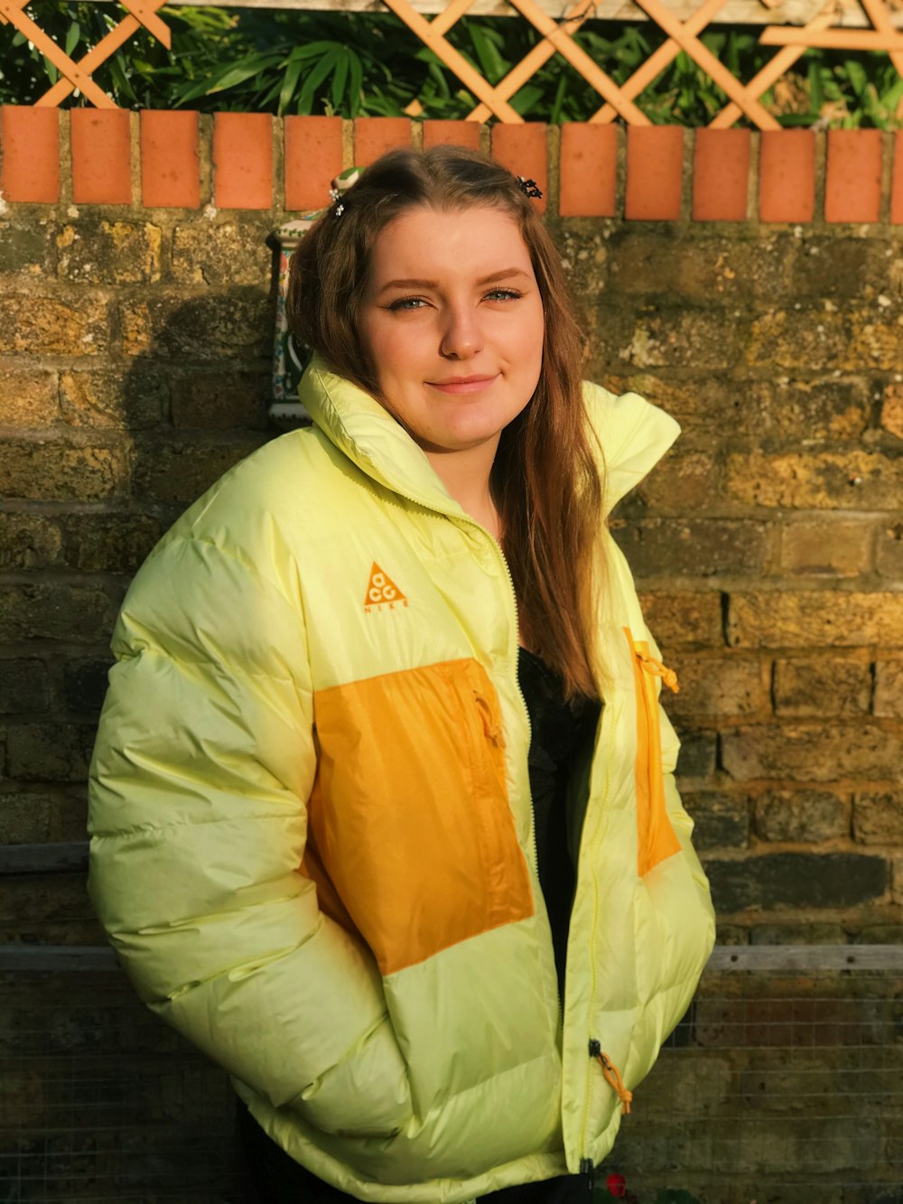 woman in green and yellow jacket smiling