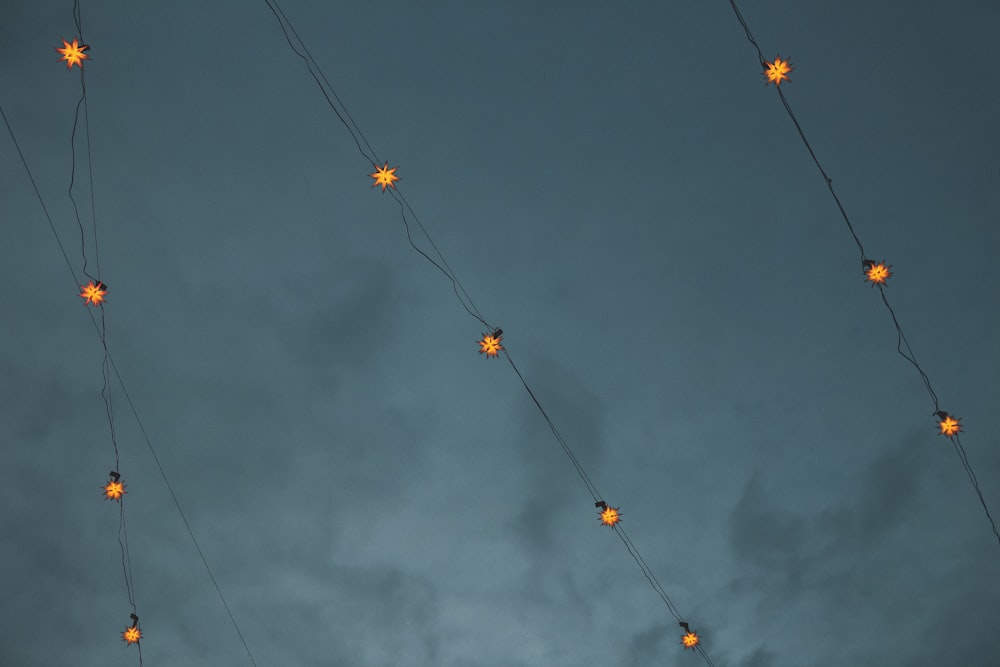 Guirlandes lumineuses jaunes et oranges sous des nuages sombres