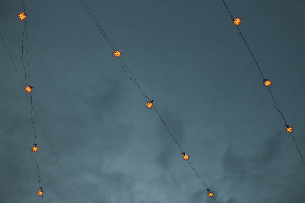 yellow and orange string lights under dark clouds