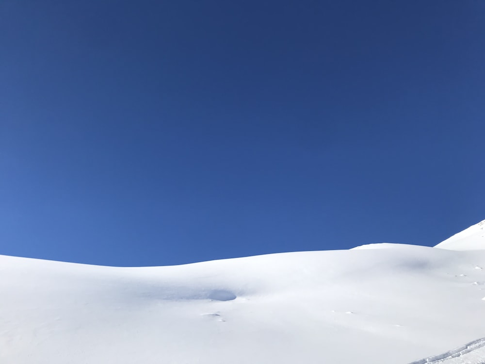 snow covered field under blue sky during daytime
