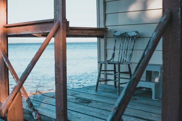 An old, weathered rocking chair on a porch of a historic Thomasville home, bathed in moonlight.