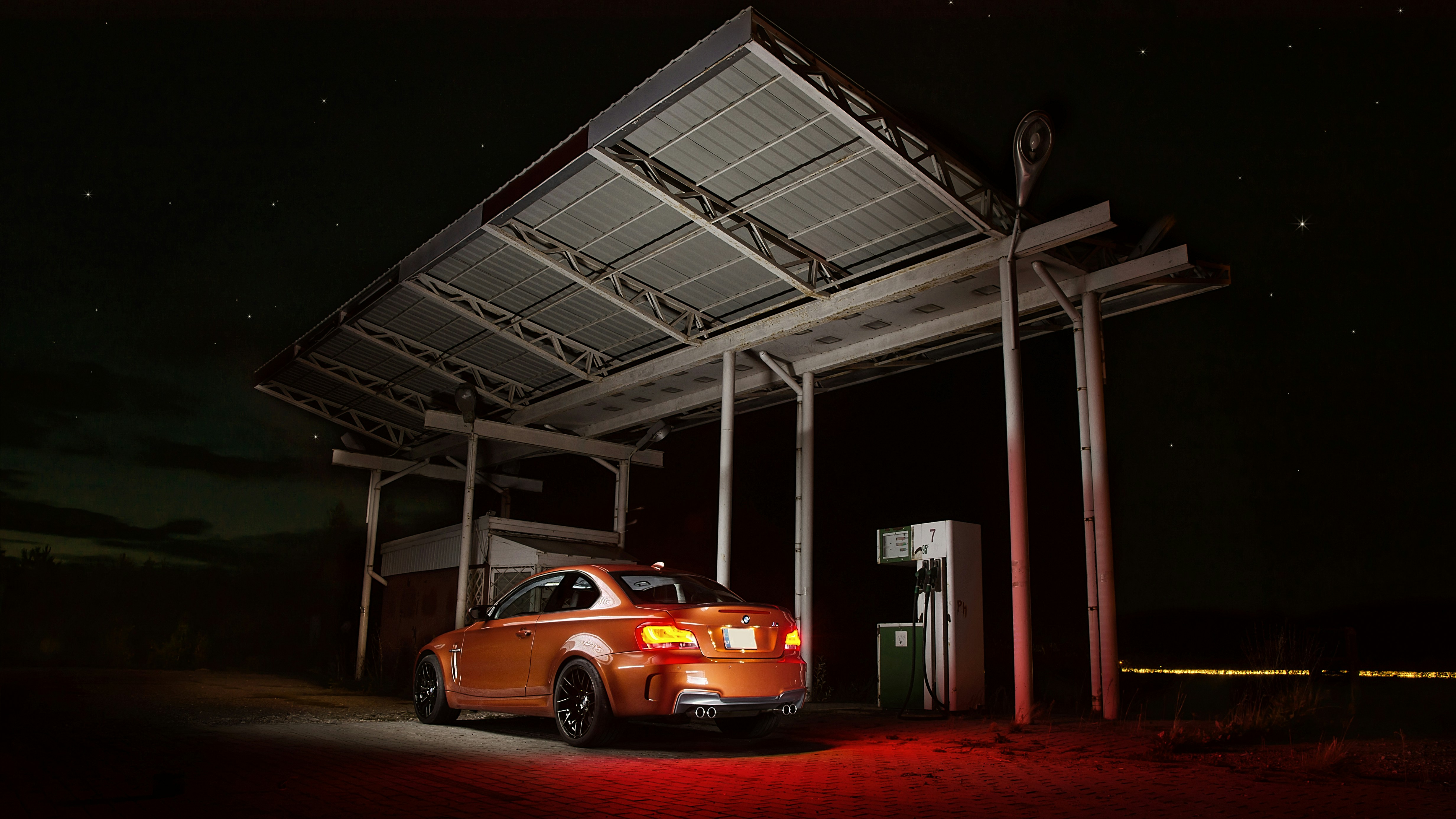 Electric compact car plugged into a home wallbox charger in a garage