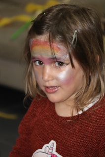 A vibrant rainbow face painting on a happy child.