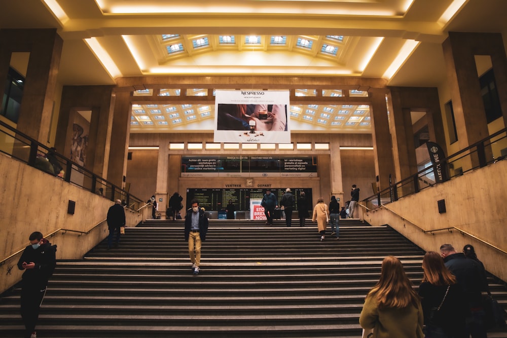 people walking on brown wooden stairs