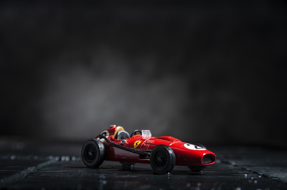 Ferrari F 1 rojo sobre superficie negra