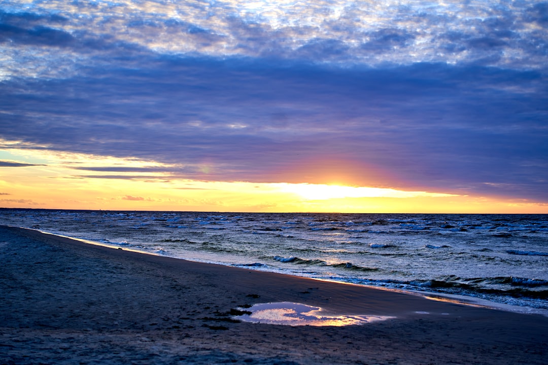 sea waves crashing on shore during sunset