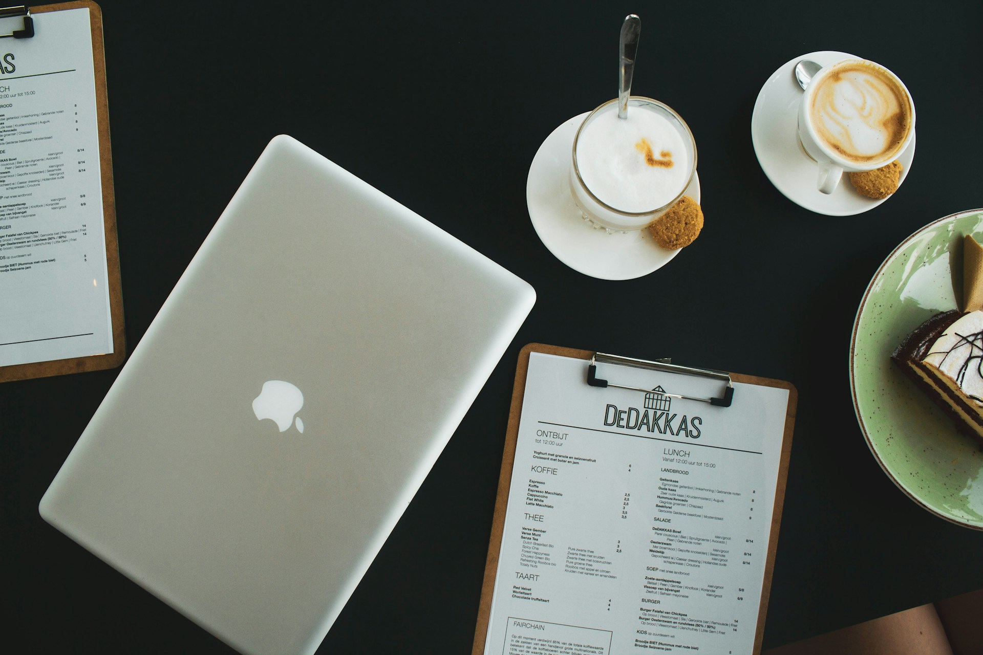 silver macbook beside white ceramic teacup on saucer