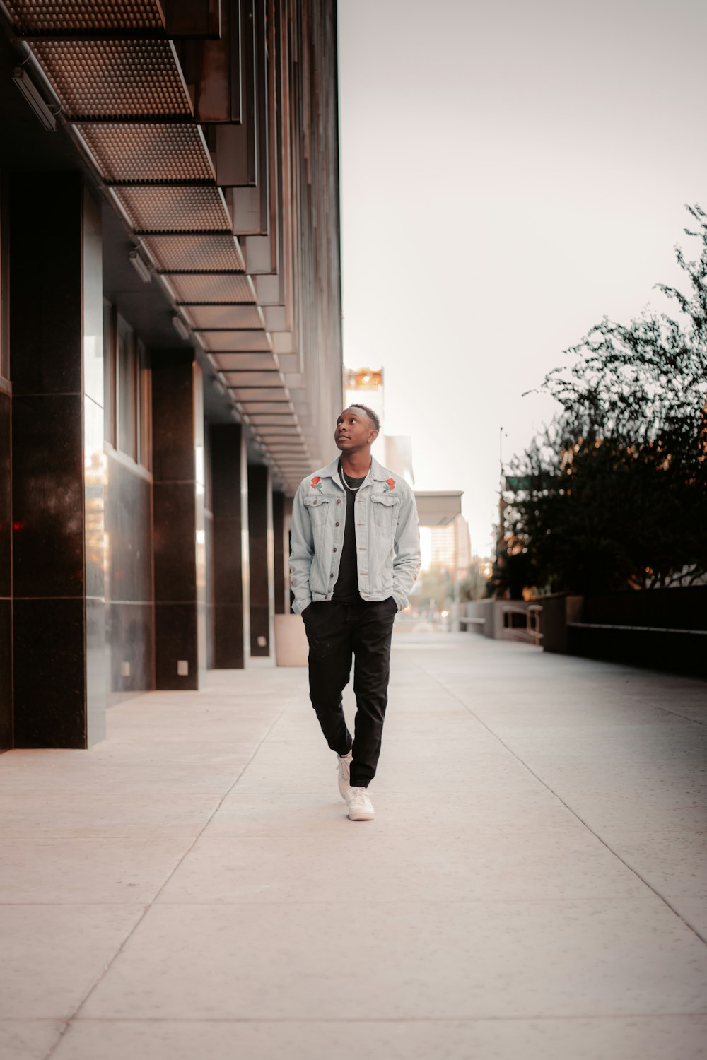 man in white dress shirt and black pants standing on white floor tiles