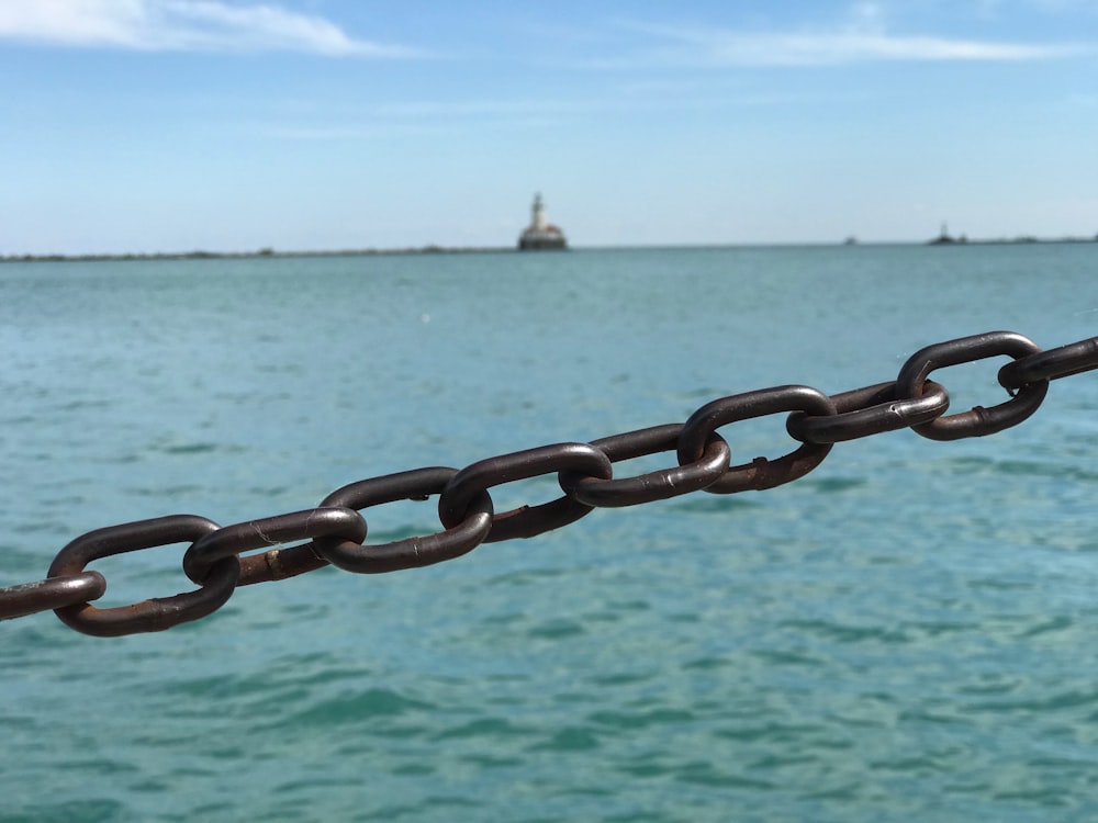 brown metal chain near body of water during daytime