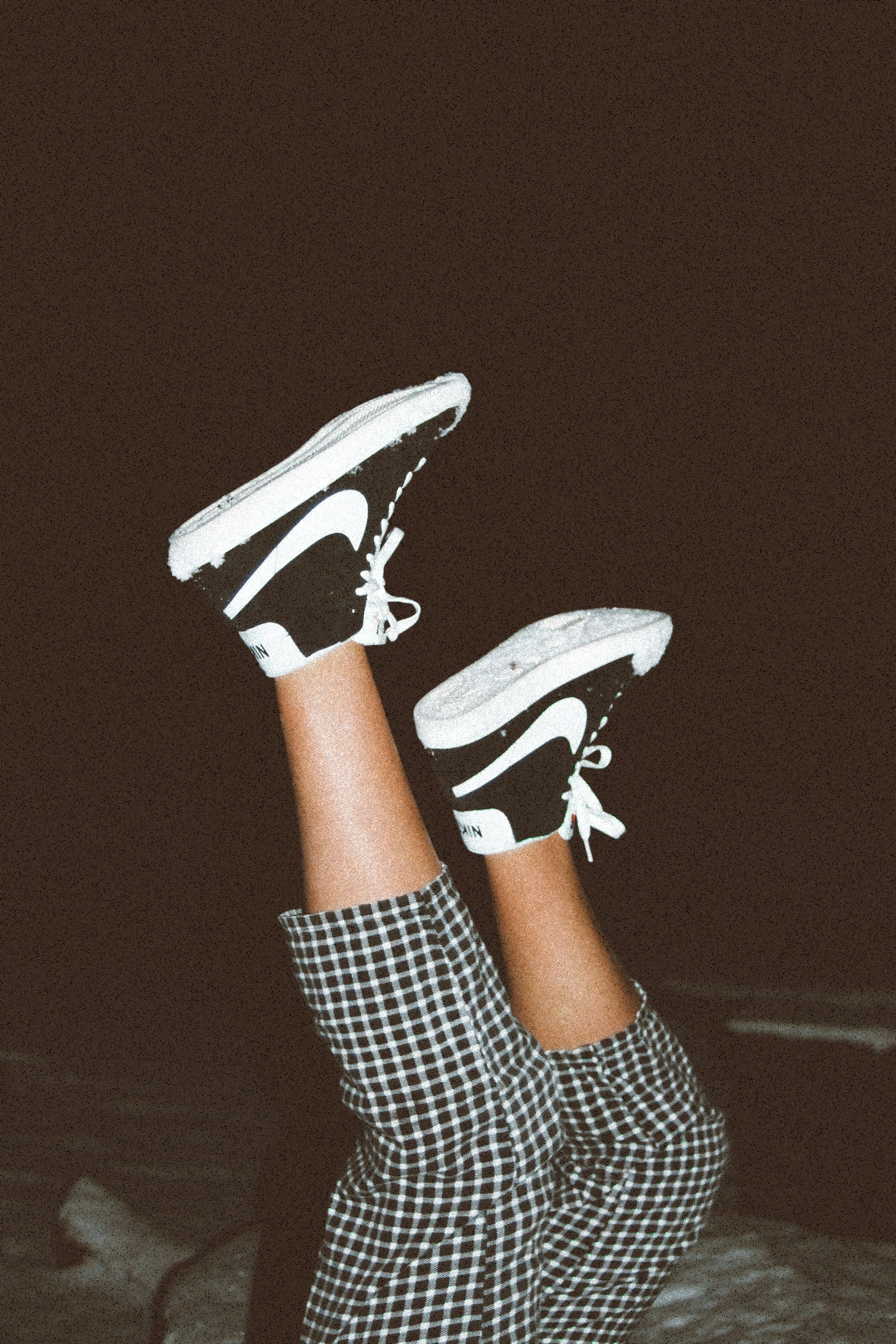 person wearing black and white nike sneakers