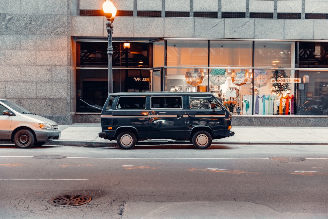 blue and white station wagon parked on sidewalk during daytime