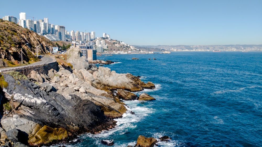 Edificio de hormigón blanco en la costa rocosa durante el día