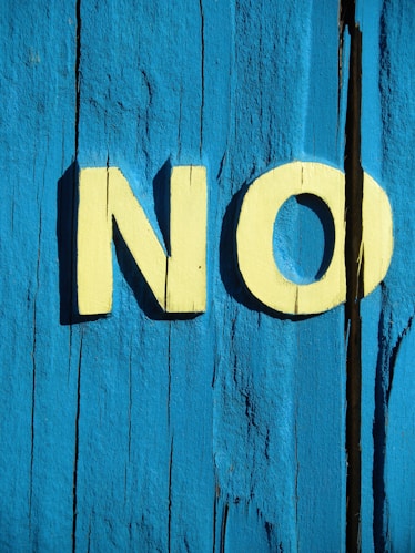 NO' painted on a blue wall, symbolising boundaries.