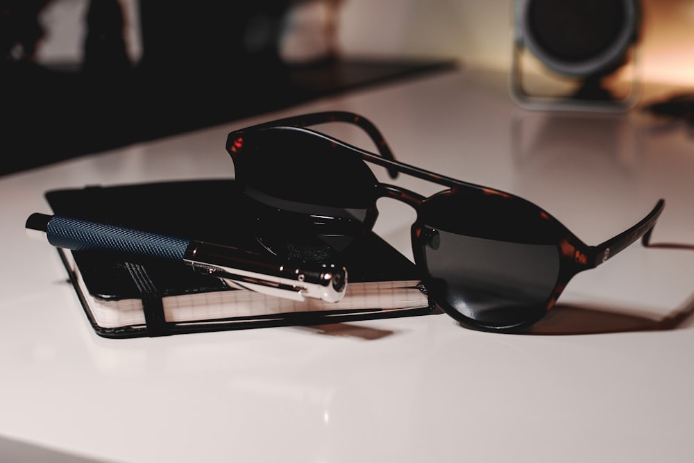 gafas de sol con montura negra sobre mesa blanca