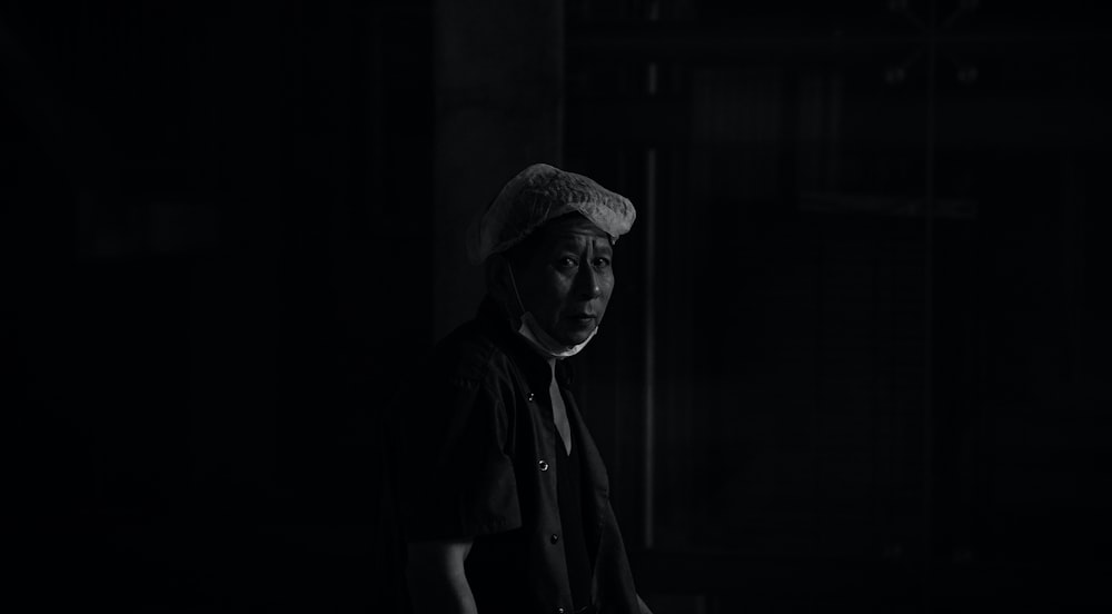 grayscale photo of man in black shirt and hat