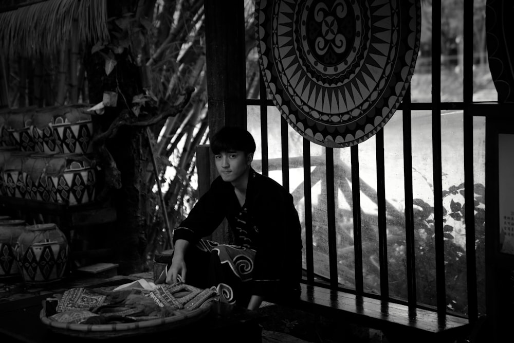 man in black jacket sitting on black wooden bench