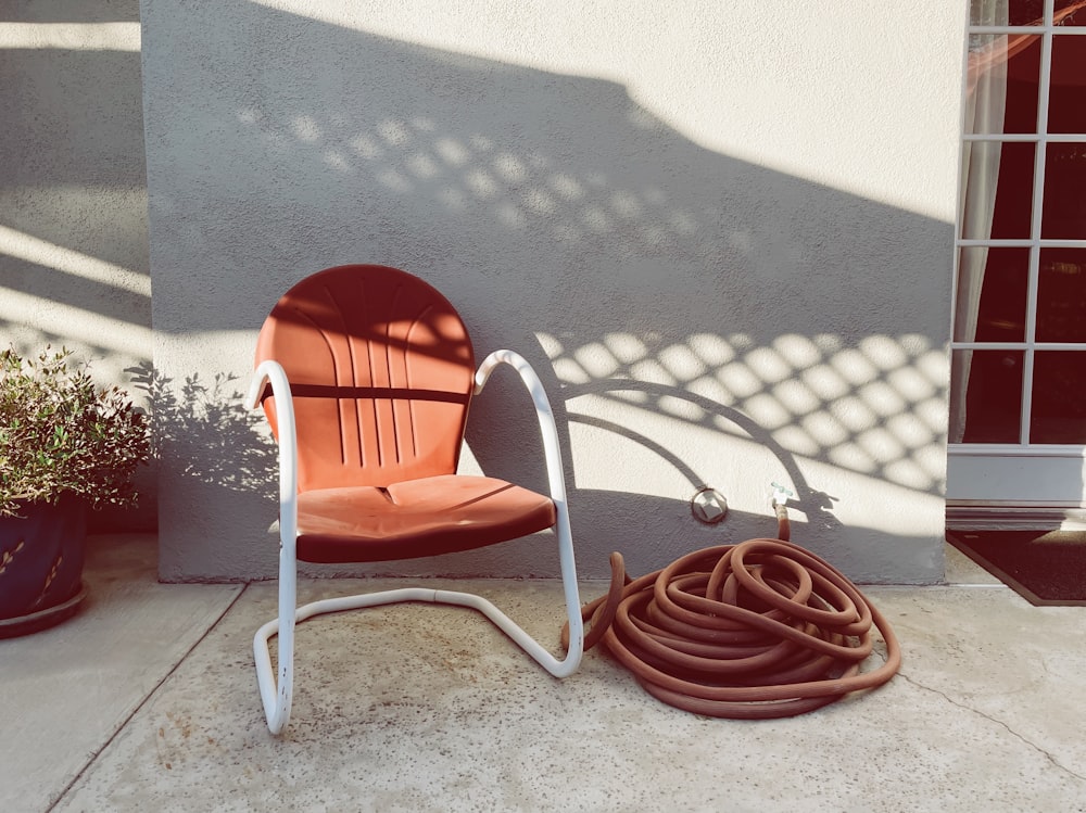 Manguera marrón sobre sillón de metal blanco