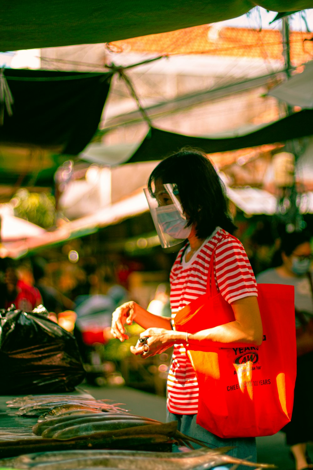 woman in red and white stripe shirt wearing white mask