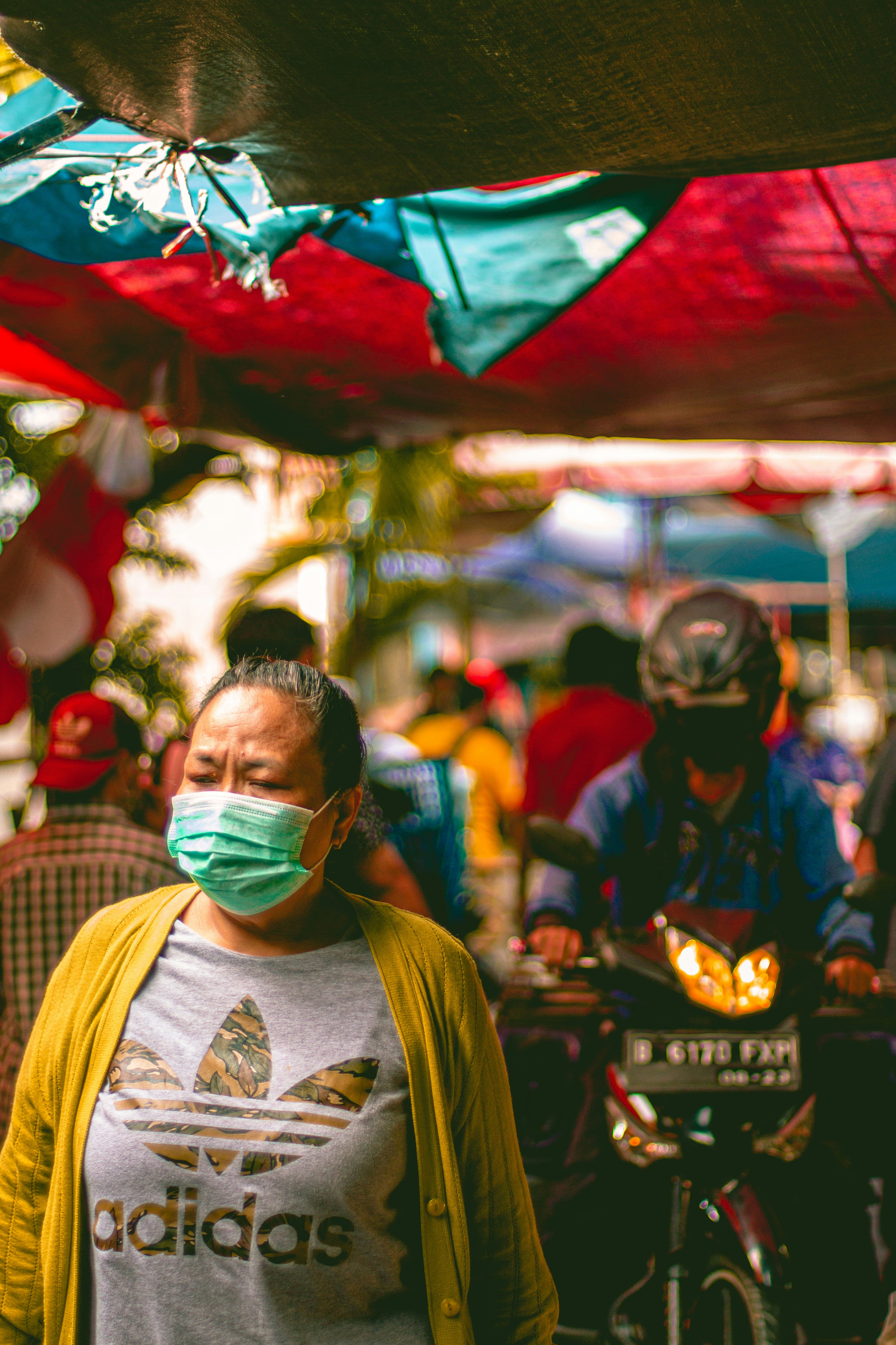 man in yellow and white shirt wearing green mask