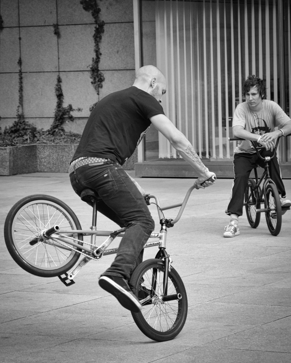 man in black t-shirt riding on bicycle in grayscale photography