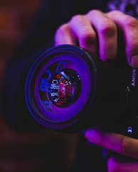 person holding black and blue camera lens
