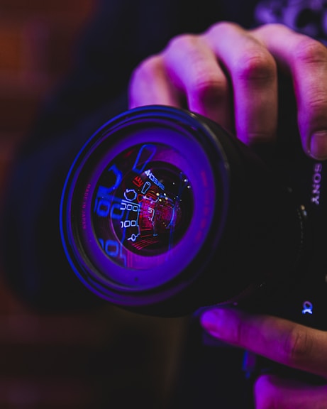 person holding black and blue camera lens