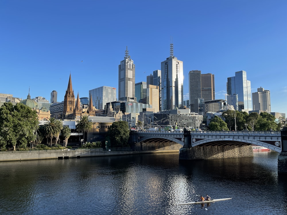 man riding on boat on river near city buildings during daytime