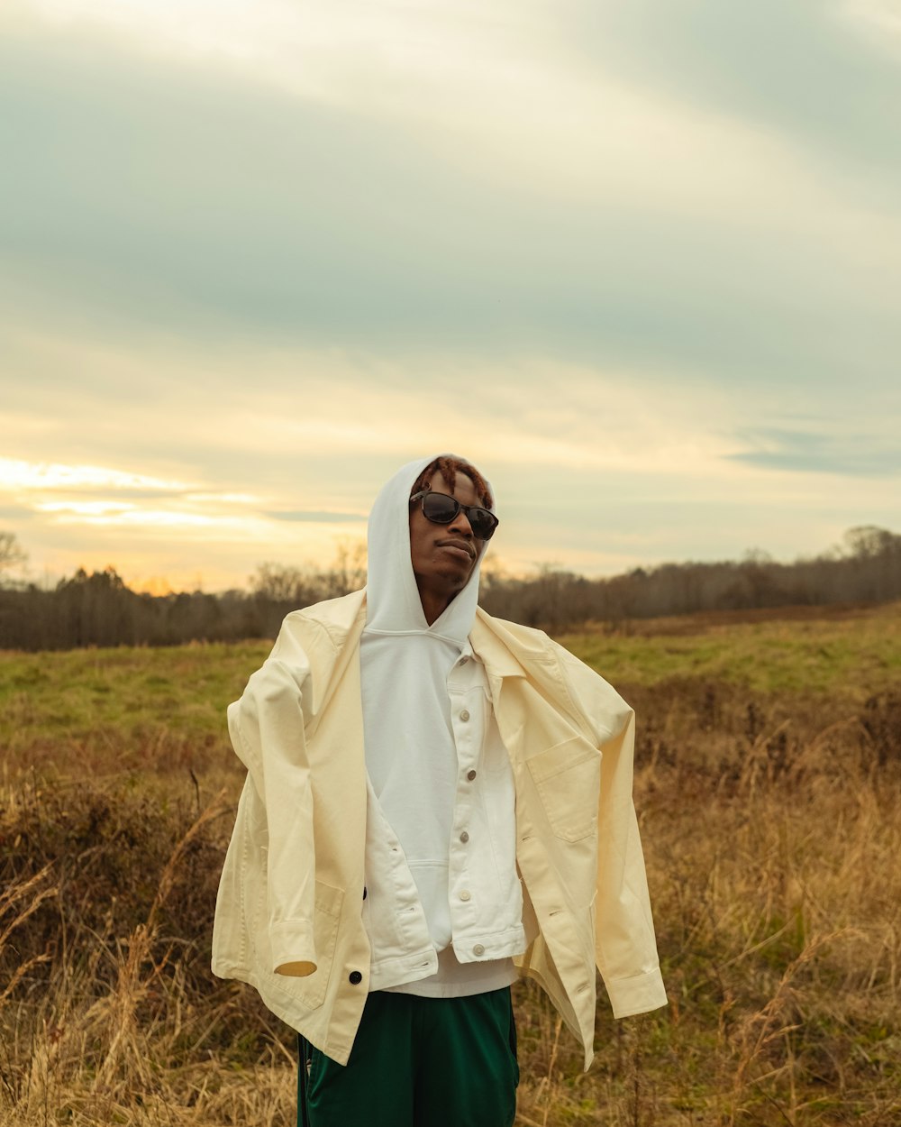 man in white robe standing on brown grass field during daytime