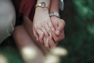 a close up of two people holding hands