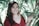 a woman in a red shirt is holding a plant