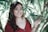 a woman in a red shirt is holding a plant