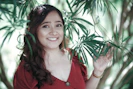 a woman in a red shirt is holding a plant