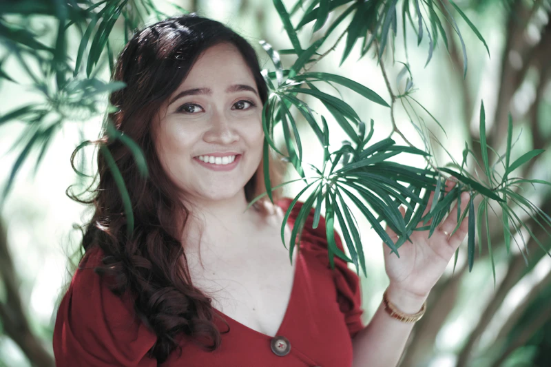 femme en chemise rouge tenant une plante