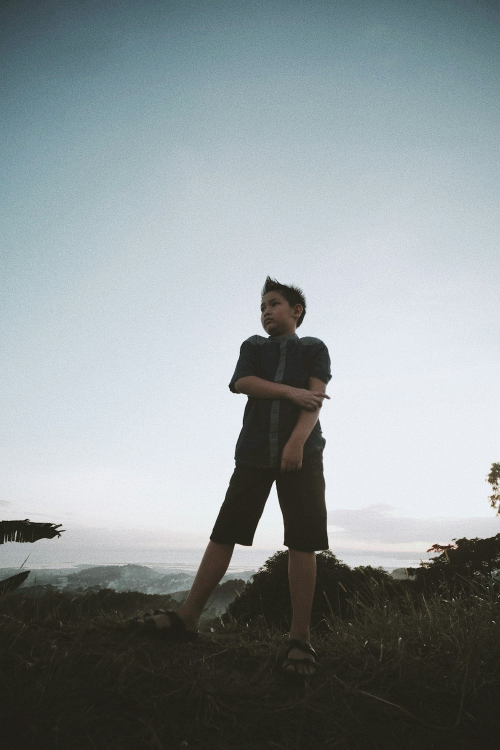 a man standing on top of a lush green hillside