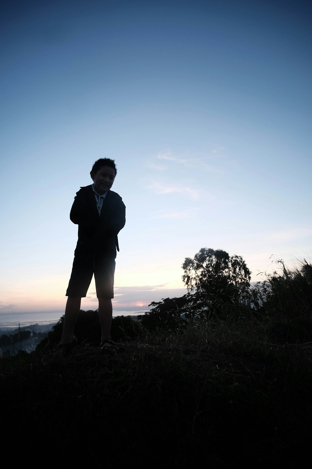 a man standing on top of a grass covered hillside