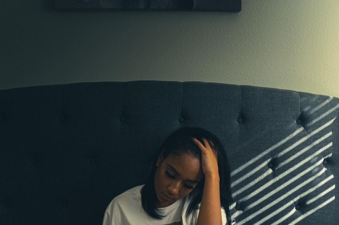 woman in white shirt sitting on black couch