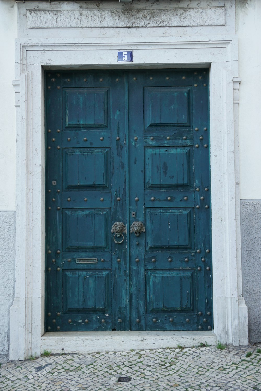 blue wooden door on white concrete wall