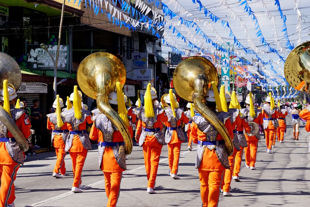 Personas con trajes naranjas y azules caminando por la calle durante el día