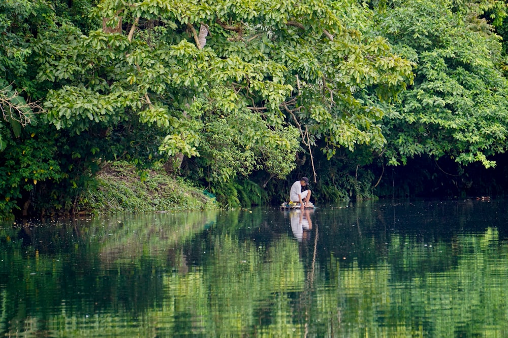 2 people on brown boat on lake during daytime