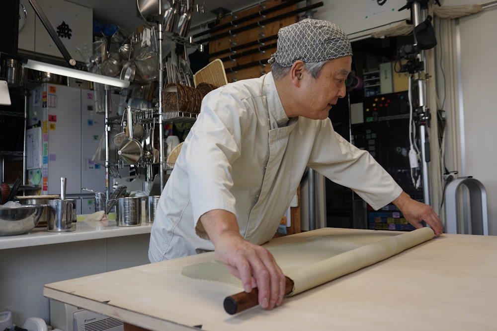 man in white dress shirt holding brown wooden rolling pin