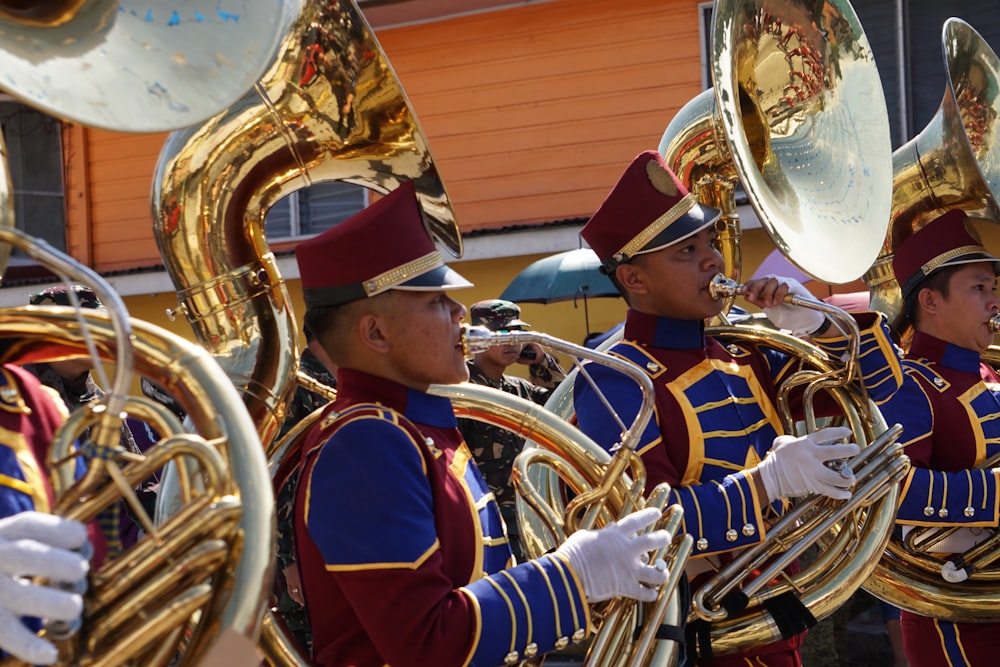 Personas con uniforme azul y rojo tocando instrumentos musicales
