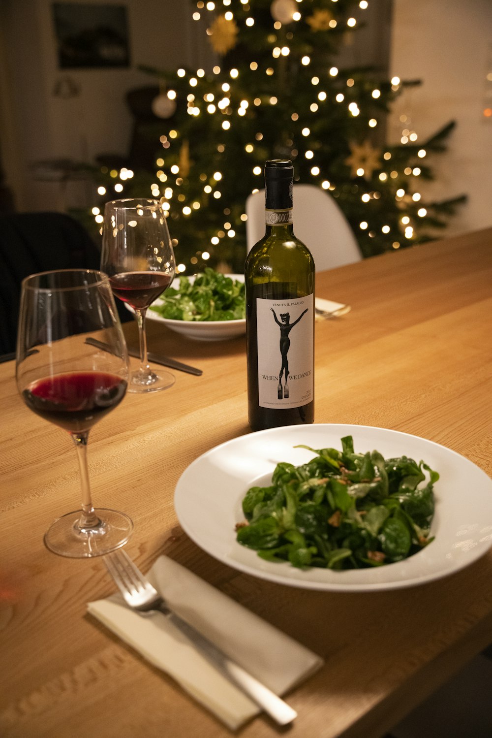 green wine bottle beside wine glass on table