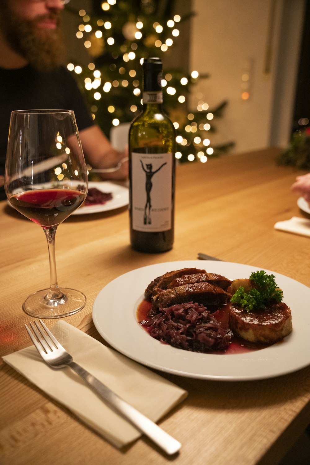 cooked food on white ceramic plate beside wine glass